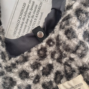 Detailed macro view of leopard print faux shearling texture with canvas label and strap