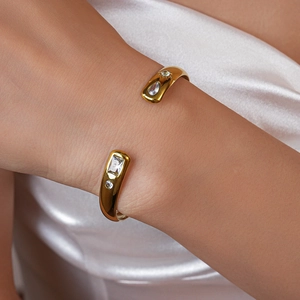 Detailed close-up of a gold-plated stainless steel cuff bracelet with sparkling cubic zirconia