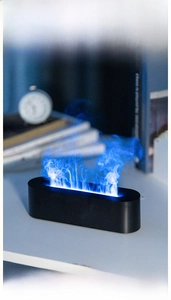 Close-up of blue 3D flame effect humidifier on a modern desk with a minimalist black base