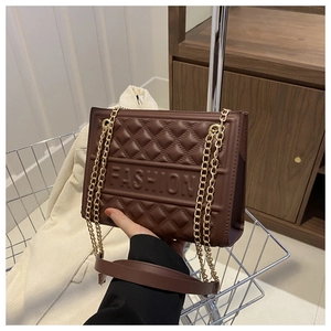 Brown embossed shoulder bag with gold chain and FASHION lettering in fashion store