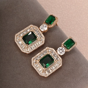 Close-up of vintage emerald style drop earrings with gold plating and paved crystals