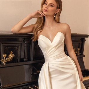 Ivory satin wedding gown with sweetheart neckline and ruched waist by an antique piano