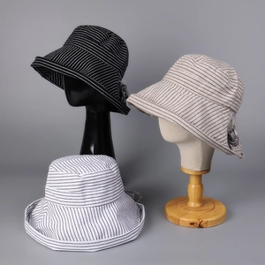 Detail of wide brim bucket hats with striped patterns and adjustable chin straps