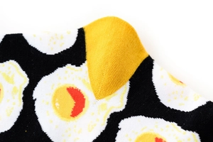 Dettaglio di calze in maglia con motivi a uovo fritto e tallone giallo a contrasto