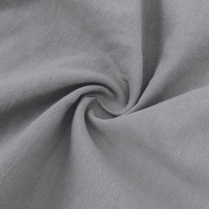Detailed macro view of the grey cotton linen fabric texture and woven patterns on the shirt