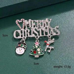 Detail of a Christmas brooch with enamel snowman and rhinestone tree on green leather