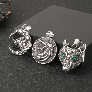 Detailed comparison of Viking wolf head pendants with green gems and moon carvings