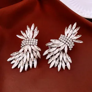 Boucles d'oreilles ailes en cristal argenté avec strass sur fond de soie rouge élégant