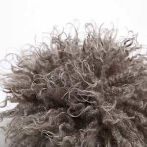 Close-up of grey curly wig texture on a stylish knitted brimless skull cap for men and women