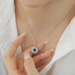 S925 sterling silver evil eye necklace with sparkling cubic zirconia on a white shirt