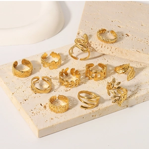 Detail view of 11-piece 18k gold plated bohemian rings on a beige textured stone base