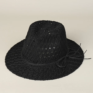 Detail of hollow-out straw texture and rope bow decoration on black sun hat