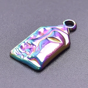 Macro view of iridescent face pendant with 18k plating and embossed detail
