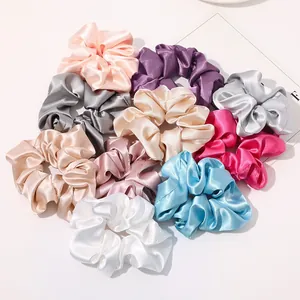 Detail of colorful silk scrunchies in various pastel shades with soft satin texture