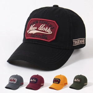 Detail view of vintage cotton baseball caps with embroidered New York patches in five colors