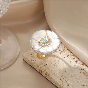 Anello barocco a fiore dorato con perla e motivo malocchio su sfondo di seta