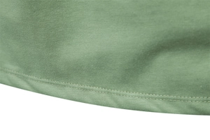 Close-up of high-quality sage green knitted fabric showing the double-needle stitched hem