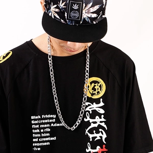 Détail d'un collier chaîne 3:1 NK argenté de style hip-hop avec un t-shirt noir à motif