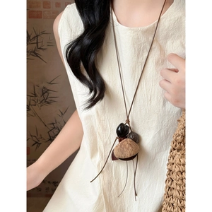Détail du collier pendentif vintage en bois avec perles de noix naturelles et cordon brun