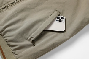 Detail of khaki jacket side pocket with phone storage and striped ribbed hem design