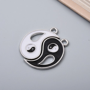 Close-up of Yin Yang Tai Chi enamel charm with metal edges for DIY jewelry making