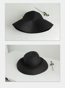 Detail view of a black wide-brim straw hat with elegant weave texture and summer sun protection