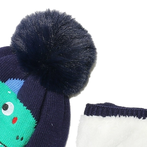 Close-up of kids winter knit hat with dinosaur embroidery and warm fleece scarf set