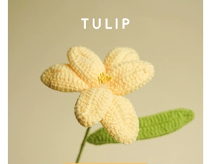 Close-up of a hand-knitted yellow tulip flower made of soft yarn with green leaves