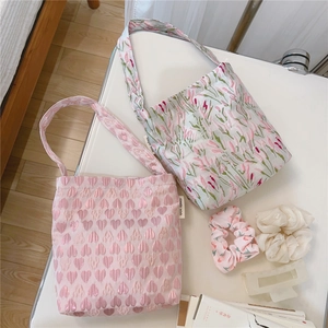 Close-up of floral tote bags set with matching hair scrunchies and a claw clip on table