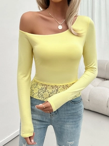 Detail of yellow long sleeve knit top with off-shoulder neckline and delicate lace trim