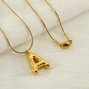 Detail of gold bubble letter A pendant on a snake chain with a lobster clasp closure