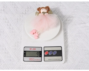 Close-up of lightweight pink mesh angel ornament weighing 9g on a digital scale