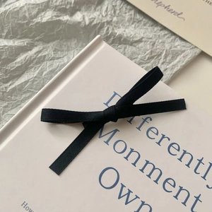 Close-up of a sweet black fabric bow hair clip on a white card with an ins-style aesthetic