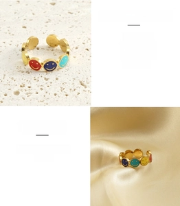 Detail of colorful enamel smiley face ring in gold stainless steel on luxury satin