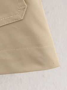 Detailed macro view of khaki trench coat fabric showing reinforced double-stitch sewing seams