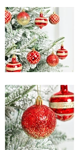 Detail of red and gold Christmas ornaments with glitter and matte textures on a snowy tree