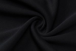 Close-up of high-density black knit fabric with elegant swirls and fine texture