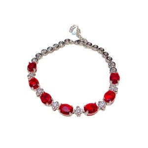 Elegant silver bracelet featuring oval ruby-red stones and floral zircon accents on white