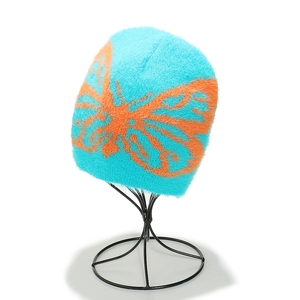 Primo piano di un berretto invernale blu soffice con motivo jacquard a farfalla arancione