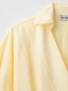 Dettaglio dell'abito a camicia giallo chiaro con tessuto in twill e cuciture di alta qualità
