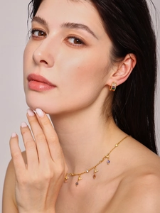 Detail of French vintage gold ear cuff with colorful glass stones on model's ear