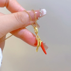Elegant gold titanium steel necklace featuring a red chili and heart pendant detail