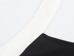 Gros plan sur la bordure blanche contrastée et le tricot noir de la robe dos nu