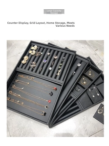 Detailed view of black PU leather jewelry display trays with various storage compartments
