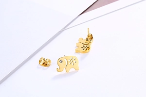 Detail of gold elephant earring featuring hollow patterns and rhinestone eye accents