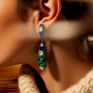 Close-up of vintage teardrop drop earring with colorful gemstones on a model ear