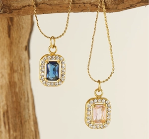 Detail of square emerald-cut pendants with blue and pink crystals on gold twisted chains