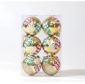 Detail of 6-piece golden Christmas ball set with hand-painted patterns in a clear box