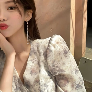 Elegant silver zircon tassel earrings with pearl necklace on a model in natural light