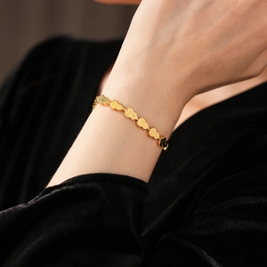 Detailed close-up of golden gourd link bracelet featuring textured and polished finishes